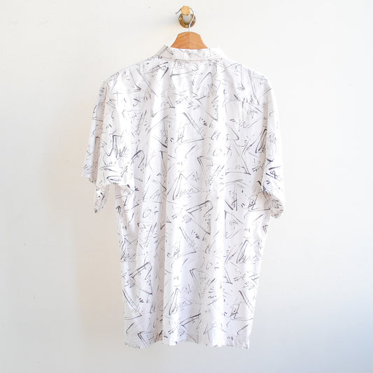 back of white vintage shirt with black pattern on a hanger in 80s or 90s style