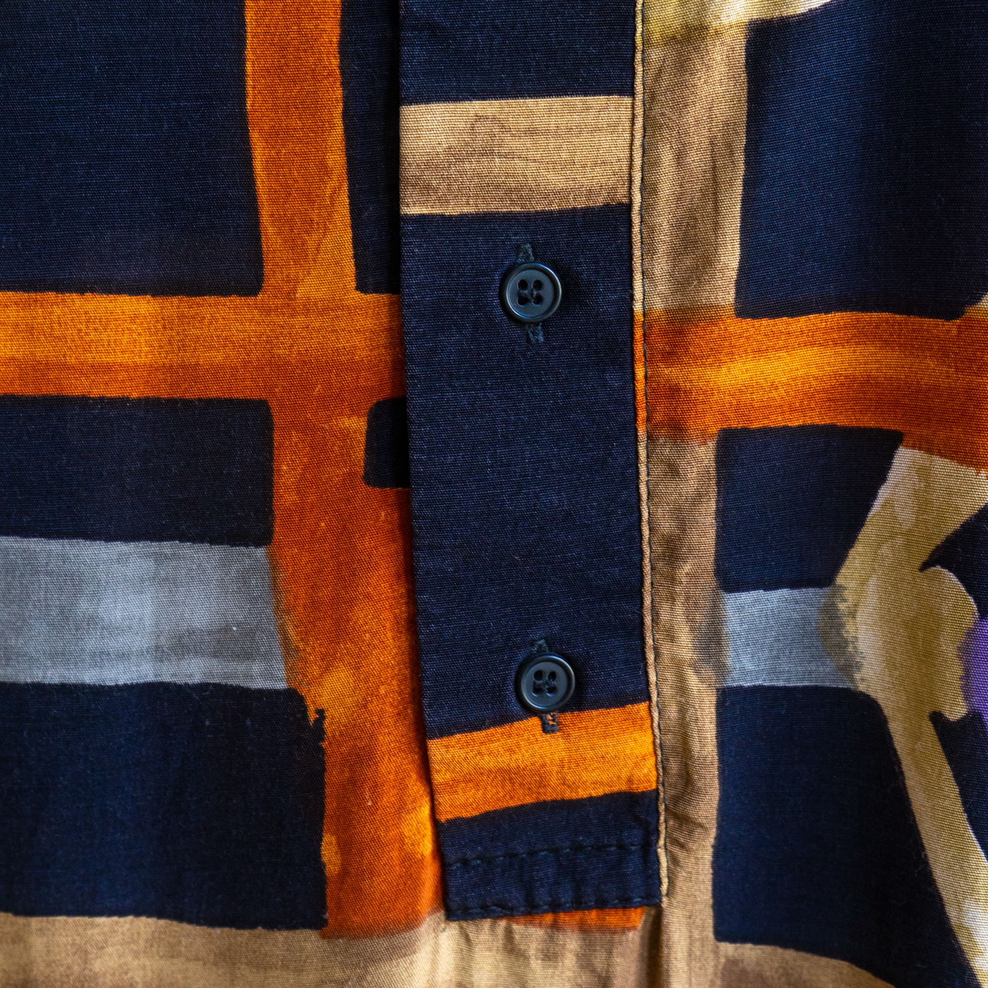 close-up of black '90s vintage shirt with orange beige grey pattern