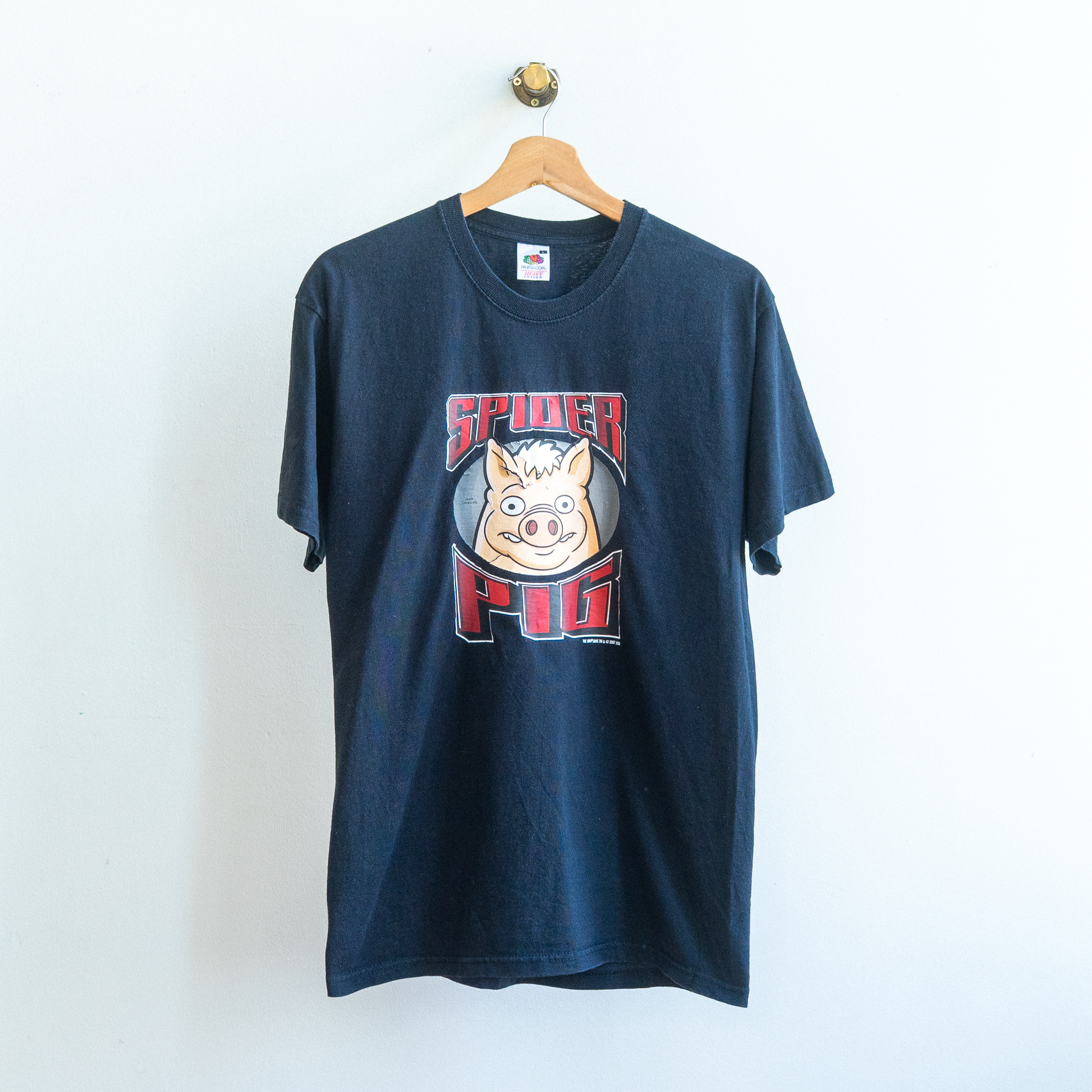 black secondhand t-shirt with a graphic design of a pig and text spider pig from the simpsons on a hanger