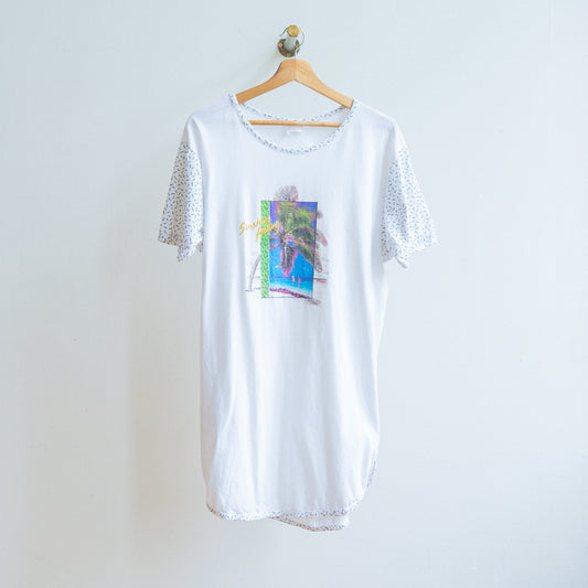 wit t-shirt kleed uit de jaren 90 met tekst sunshine feeling grafishce print van palmboom en korte mouwen met blauwe korte streepjes aan kapstok fresh vintage