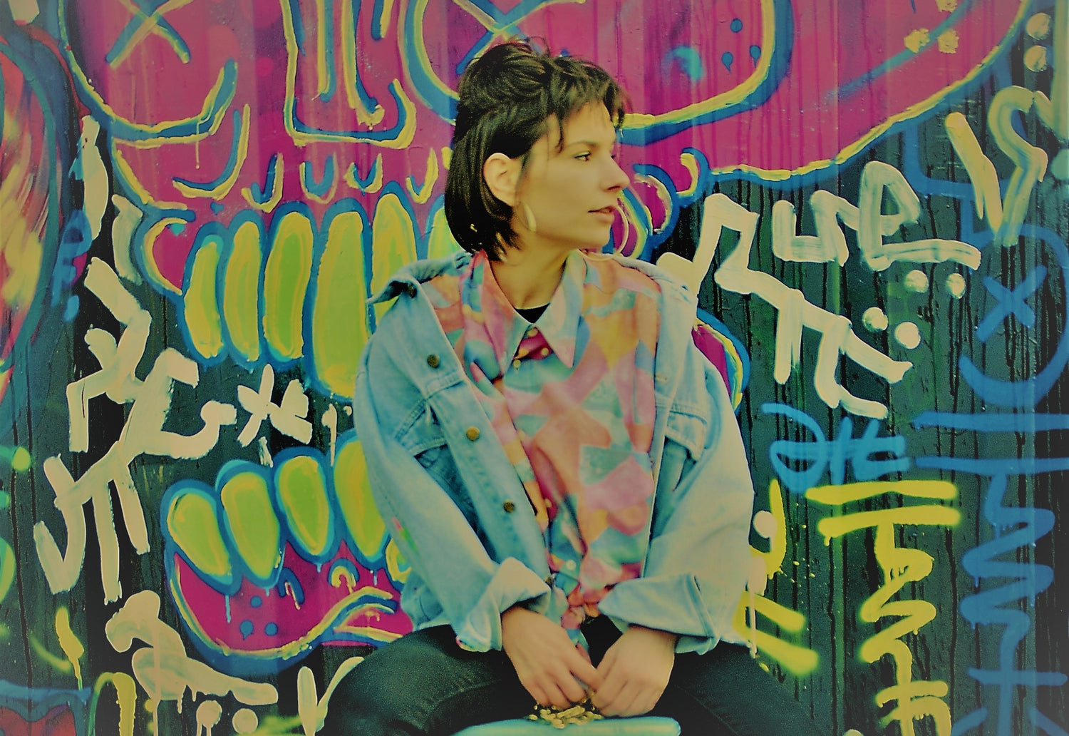 girl-wearing-80s-and-90s-vintage-clothing-in-front-of-graffiti-wall