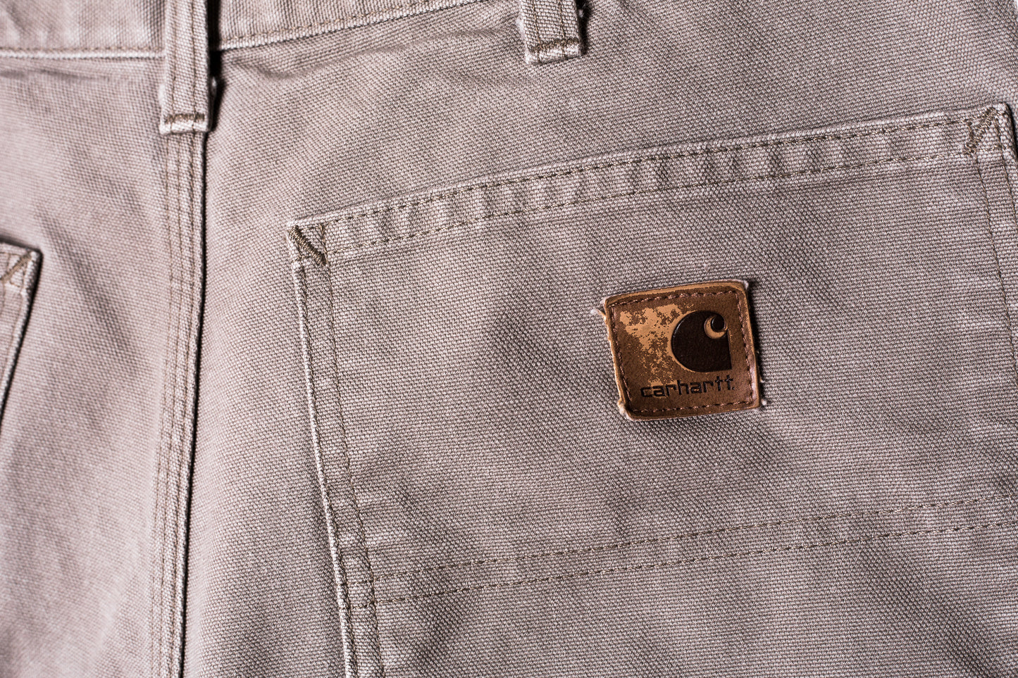 detail-achterzak-grijze-carhartt-jeans-met-leren-carhartt-logo