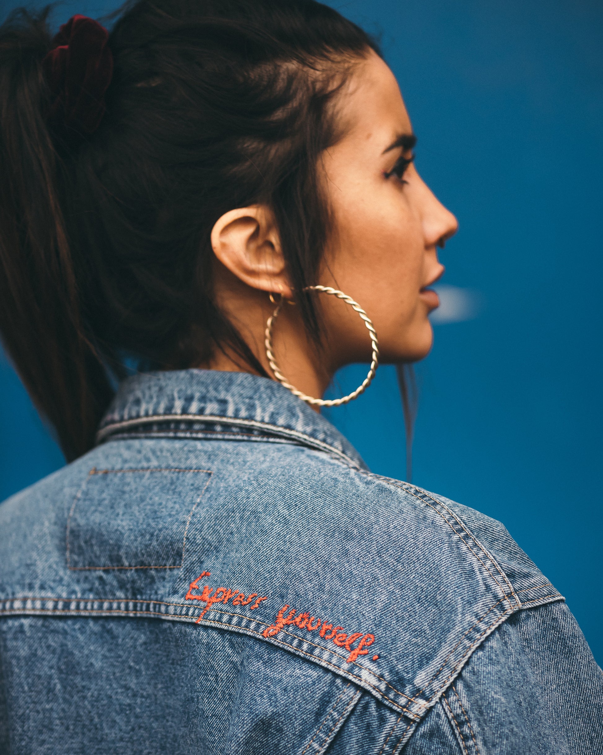 Young-woman-wearing-jeans-jacket-with-embroidery-express-yourself